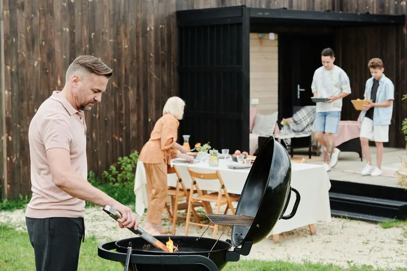 A happy family enjoys an outdoor barbecue in their backyard, fostering togetherness